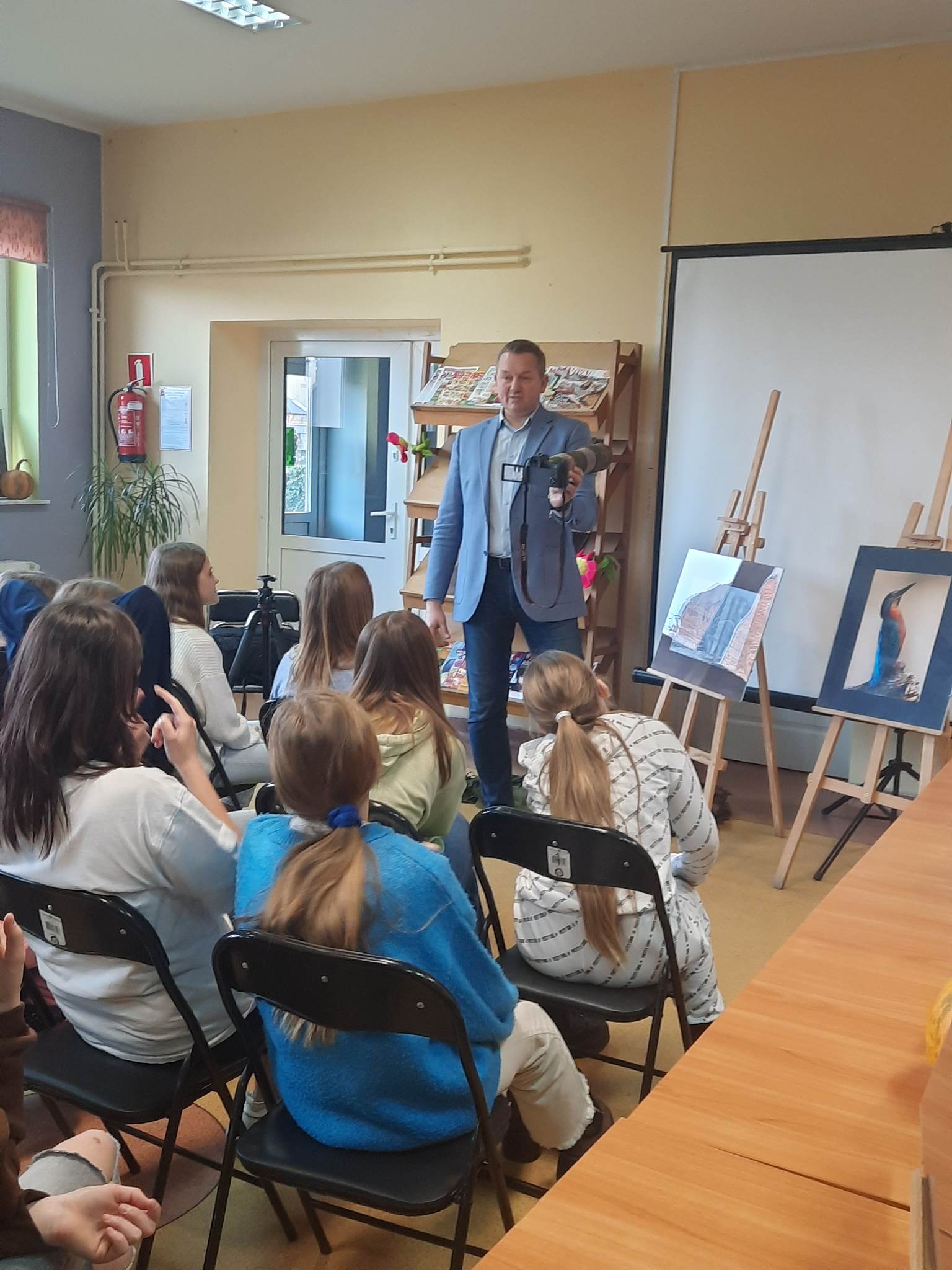 Uczniowie szkoły podstawowej w Pomianowie z autorem wystawy fotografii Przyroda naszego regionu w miejscowej bibliotece