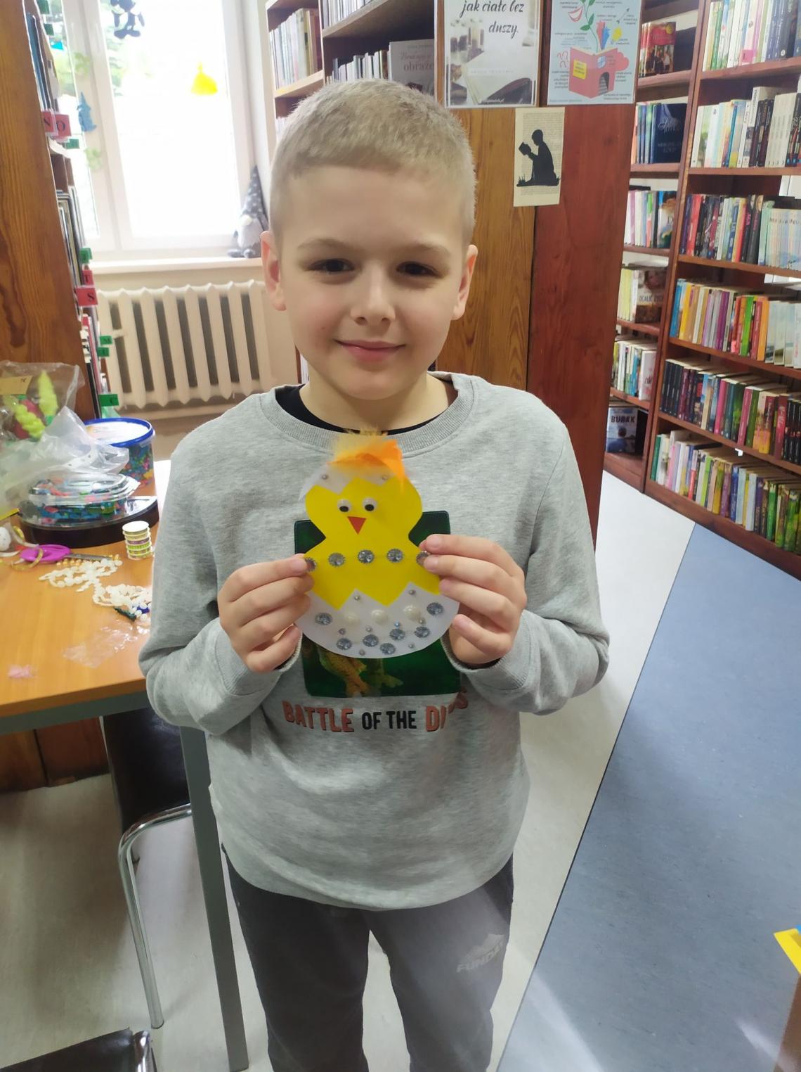 Uczestnik warsztatów wielkanocnych w bibliotekach na terenie Gminy Białogard z wykonaną własnoręcznie ozdobą wielkanocną