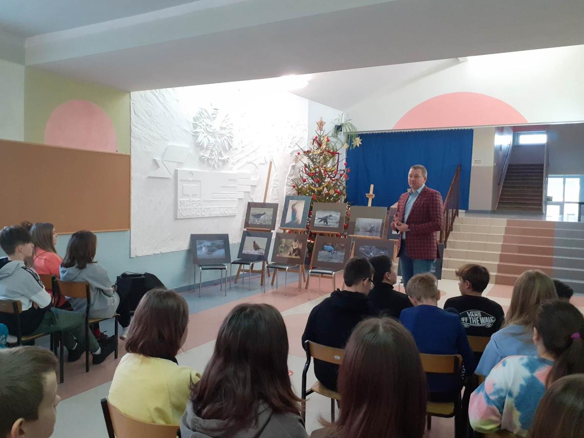 Uczniowie szkoły podstawowej w Rogowie z autorem wystawy  fotografii Przyroda naszego regionu w miejscowej bibliotece (2)