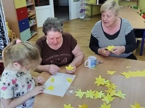 Czytelniczki w bibliotece w Stanominie na zajęciach plastycznych podczas wykonywania papierowych żółtych żonkili